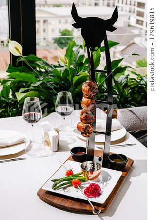 Gourmet meal presented elegantly on a modern serving rack in a chic restaurant 129619815