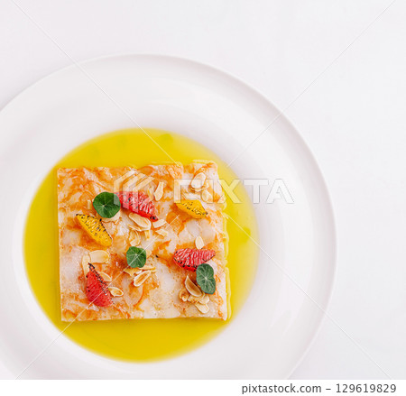 Unique dessert presentation with delicate fruits and syrup on plate 129619829