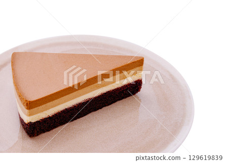 Layers of decadent dessert on a minimalist plate showcasing rich flavors 129619839