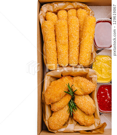 Crispy golden appetizers served with dipping sauces in a takeout box 129619867