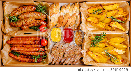 Savoring a delicious meal with assorted sausages, bread, and golden potatoes Savoring a delicious meal with assorted sausages, bread, and golden potatoes 129619929