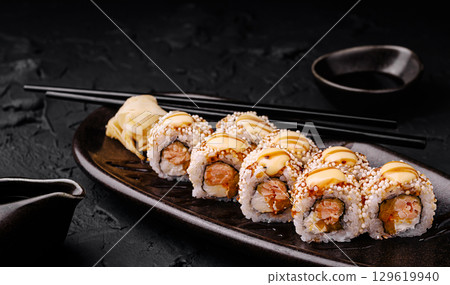 Sushi rolls served on a wooden platter with wasabi and chopsticks nearby Sushi rolls served on a wooden platter with wasabi and chopsticks nearby 129619940