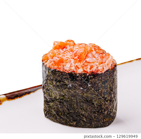 Sushi masterpiece featuring salmon on a bed of seaweed served in a restaurant 129619949
