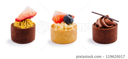 Assorted tarts with fruit and cream on a white background in a dessert display 129620017