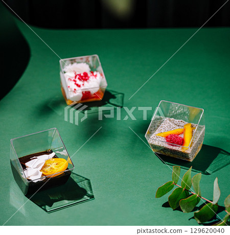 Colorful desserts arranged on a green table with fresh ingredients nearby Colorful desserts arranged on a green table with fresh ingredients nearby 129620040