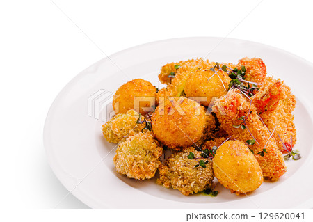 Deliciously crispy fried snacks served on a white plate at a casual gathering Deliciously crispy fried snacks served on a white plate at a casual gathering 129620041
