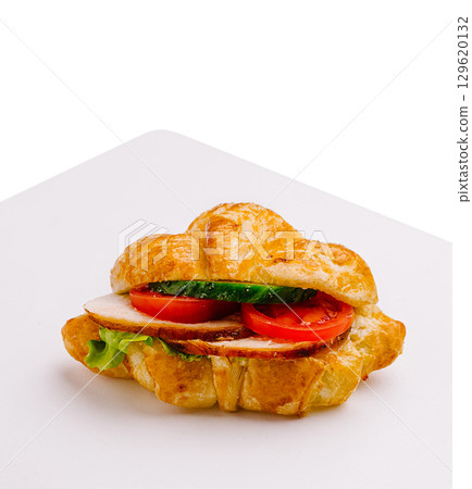 Fresh croissant sandwich featuring turkey, tomatoes, and lettuce Fresh croissant sandwich featuring turkey, tomatoes, and lettuce 129620132