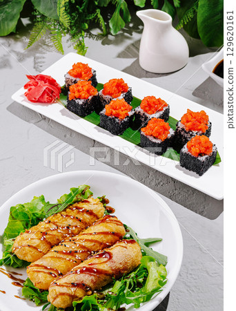Delicious sushi and rolls served on elegant plates for a gourmet experience 129620161