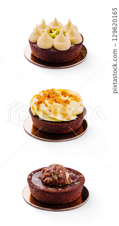 Delicious variety of gourmet chocolate tarts with unique toppings displayed 129620165