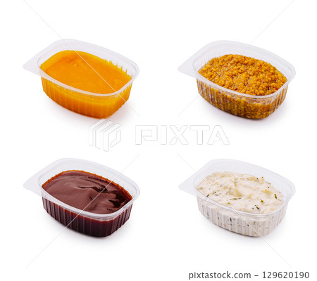 Selection of four different sauces in plastic containers on a white background Selection of four different sauces in plastic containers on a white background 129620190
