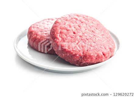 Raw burger beef patties on plate isolated on white background. 129620272