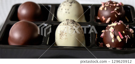 Box of white and dark chocolate-coated marshmallow cream treats 129620912