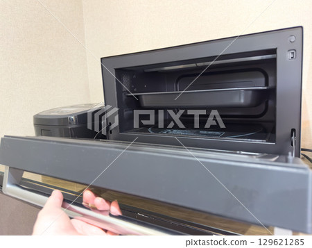 The hand that operates the microwave oven 129621285