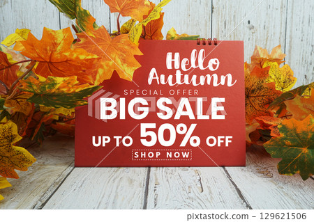Hello Autumn Big Sale 50% text with maple leaf decorated on wooden background 129621506