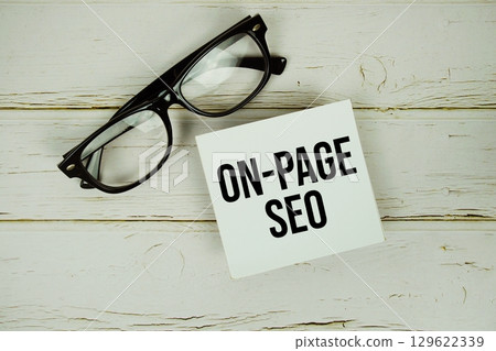 On-page SEO text message on paper with eyeglasses on wooden background 129622339
