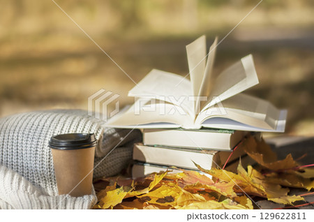 books lies near a warm scarf and coffee against the background of yellow leaves books lies near a warm scarf and coffee against the background of yellow leaves 129622811
