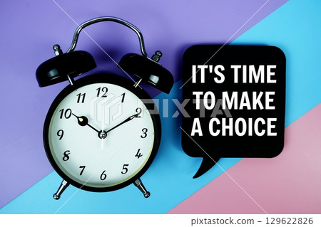 It's Time To Make A Choice text on speech bubble with alarm clock top view on blue, purple and pink geometric background 129622826