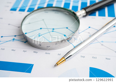Magnifying glass on data business graphs paper. 129622991