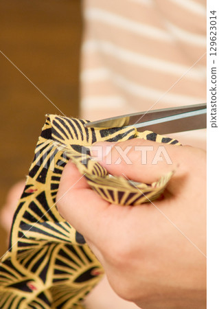 Close-up of a woman's hands making handmade accessories. The process of making a button. Close-up of a woman's hands making handmade accessories. The process of making a button. 129623014