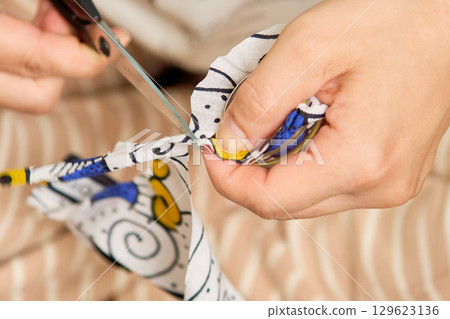 Close-up of a woman's hands making handmade accessories. The process of making a button. 129623136