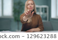 A woman is watching holographic screens. 129623288
