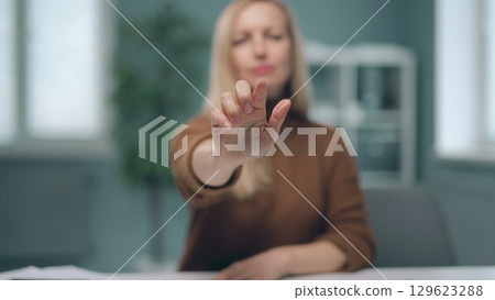 A woman is watching holographic screens. A woman is watching holographic screens. 129623288