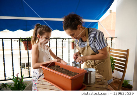 Mother and Daughter Gardening Together on a Balcony Mother and Daughter Gardening Together on a Balcony 129623529
