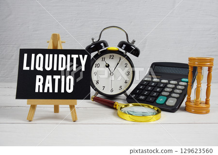 Liquidity Ratio text with alarm clock and calculator on wooden background 129623560