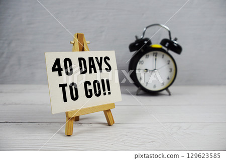40 Days To Go! text with easel and alarm clock on wooden background 40 Days To Go! text with easel and alarm clock on wooden background 129623585
