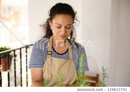 Woman Gardening on Balcony Enjoying a Leisure Activity in a Peaceful Setting Woman Gardening on Balcony Enjoying a Leisure Activity in a Peaceful Setting 129623743
