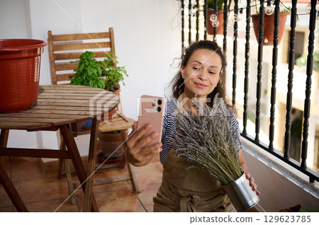 Woman Enjoying Gardening Activity on Balcony with Lavender Bouquet 129623785