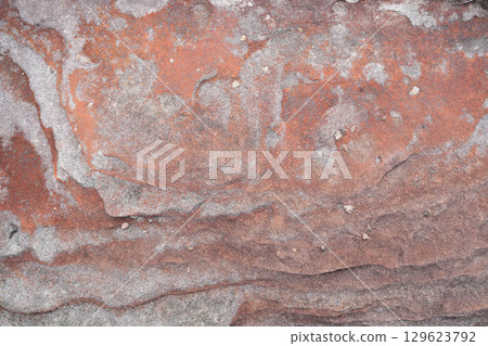 Natural red stone wall with wavy Cross-Bedding texture and white stains Natural red stone wall with wavy Cross-Bedding texture and white stains 129623792
