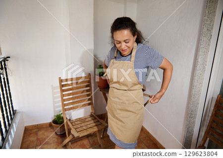 Woman Preparing for Gardening on a Cozy Balcony Space Outdoors 129623804