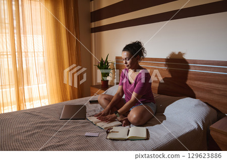 Woman Sitting on Bed Writing in Notebook During Daytime Woman Sitting on Bed Writing in Notebook During Daytime 129623886