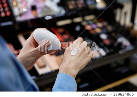 A woman is carefully applying a nourishing cream to her hand A woman is carefully applying a nourishing cream to her hand 129624060