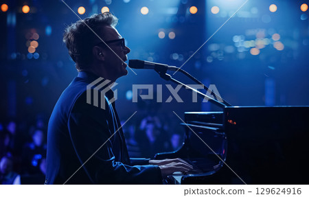 professinal pianist playing on piano at dark stage, man play at performance on grand piano instrument, back light and illumination 129624916