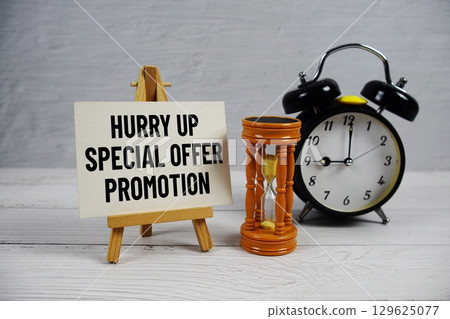 Hurry Up Special Offer Promotion text with hourglass and alarm clock on wooden background 129625077