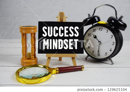Success Mindset text with magnifying glass, hourglass and alarm clock on wooden background 129625104