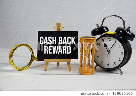 Cash Back Reward text with magnifying glass, hourglass and alarm clock on wooden background Cash Back Reward text with magnifying glass, hourglass and alarm clock on wooden background 129625106