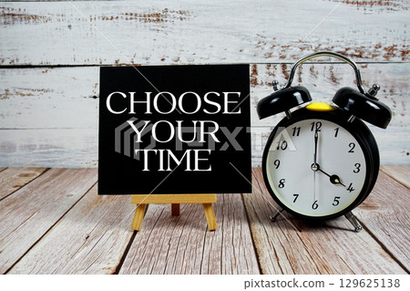 Choose Your Time text with easel and alarm clock on wooden background 129625138