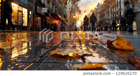 Fallen autumn leaves decorating wet pavement in barcelona, spain 129626270