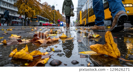 People walking on rainy autumn street in european city 129626271