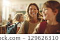 Smiling teacher greeting students in classroom before math lesson 129626310