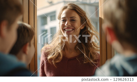 Smiling teacher greeting students before math lesson in classroom Smiling teacher greeting students before math lesson in classroom 129626313