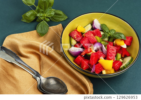 Bowl of salad with watermelon, cucumber. 129626953