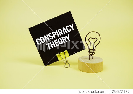 Conspiracy Theory text message on sticky note on yellow background 129627122