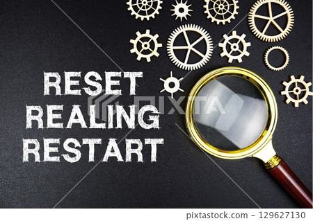 Reset Realign Restart text message with magnifying glass on black background Reset Realign Restart text message with magnifying glass on black background 129627130