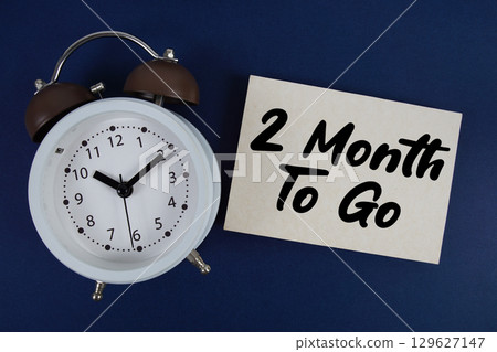 2 Month To Go text written on paper with alarm clock on blue background 2 Month To Go text written on paper with alarm clock on blue background 129627147