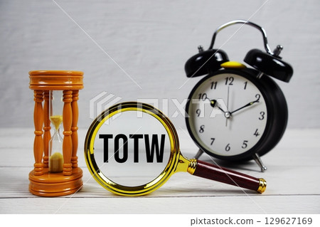 TOTW abbreviation of Time Off for Time Worked text with alarm clock on wooden background 129627169