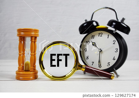 EFT Earliest Finish Time text with alarm clock on wooden background 129627174